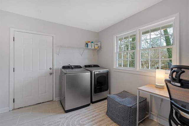 clothes washing area with washer and dryer and light tile patterned floors