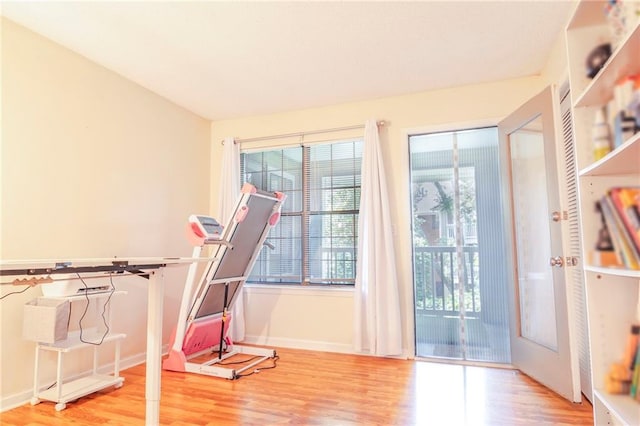 workout room with light wood finished floors and baseboards