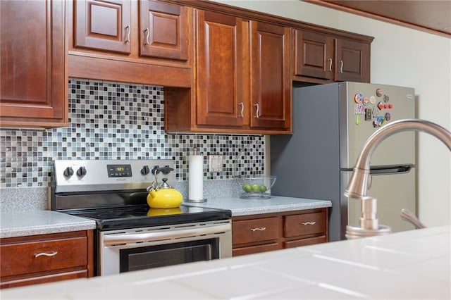 kitchen with stainless steel appliances, tasteful backsplash, and light countertops