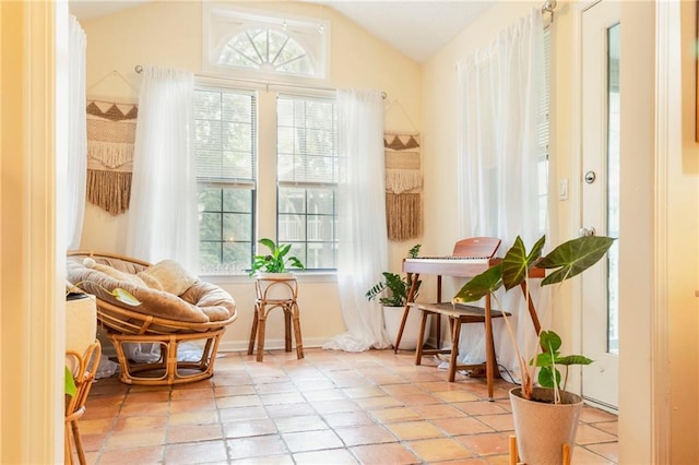 sitting room with lofted ceiling, plenty of natural light, and light tile patterned flooring