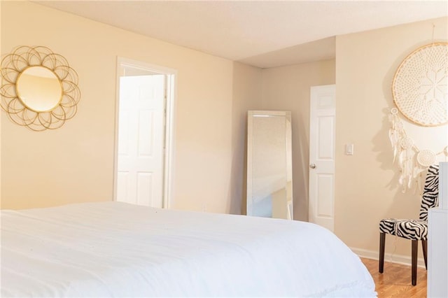 bedroom with baseboards and wood finished floors