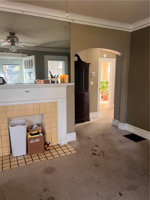 unfurnished living room with ceiling fan, carpet, and ornamental molding