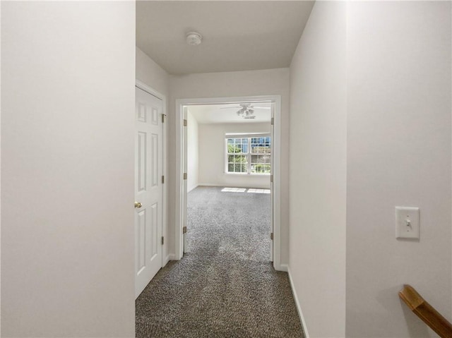 hallway featuring dark colored carpet