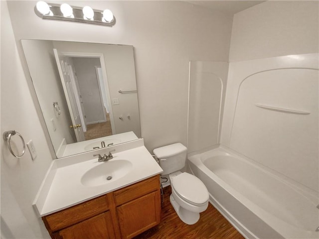 full bathroom with toilet, washtub / shower combination, wood-type flooring, and vanity