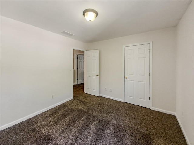 unfurnished bedroom with dark colored carpet