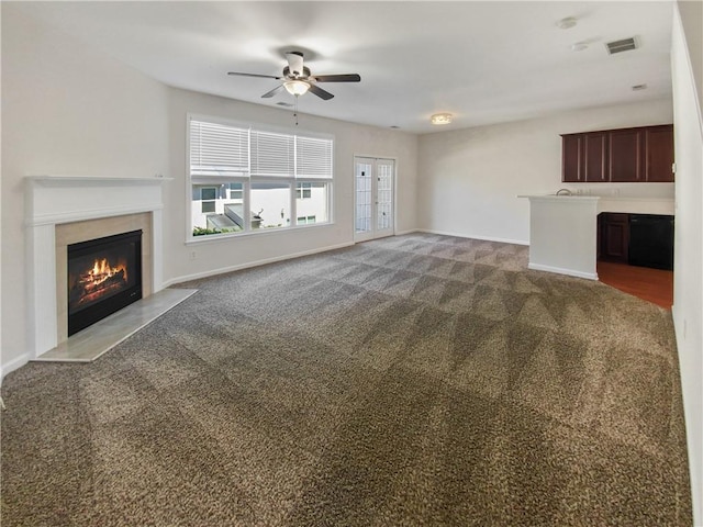 unfurnished living room featuring ceiling fan and carpet