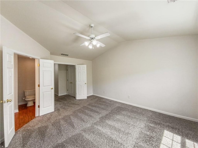 unfurnished bedroom featuring lofted ceiling, ensuite bathroom, ceiling fan, and carpet flooring