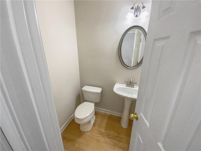 bathroom with toilet and wood-type flooring