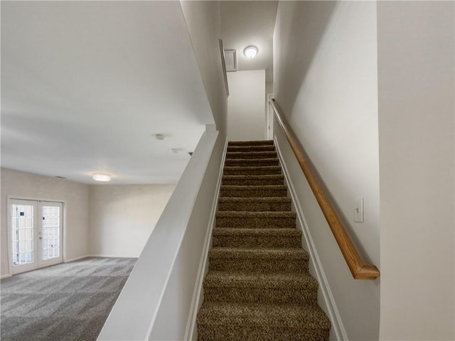 stairs with french doors and carpet