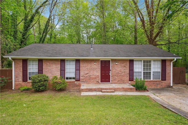 single story home featuring a front yard, fence, and brick siding