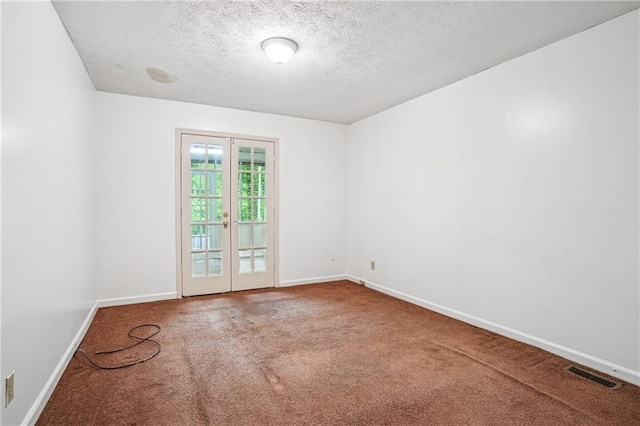 carpeted empty room with french doors, visible vents, baseboards, and a textured ceiling