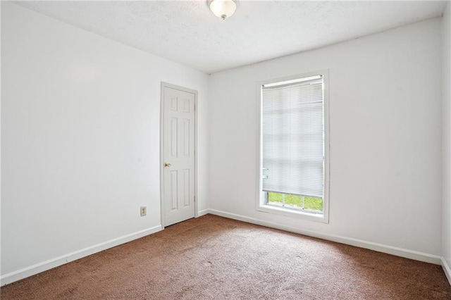 carpeted spare room with baseboards
