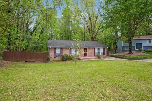 single story home featuring fence, a front lawn, and brick siding