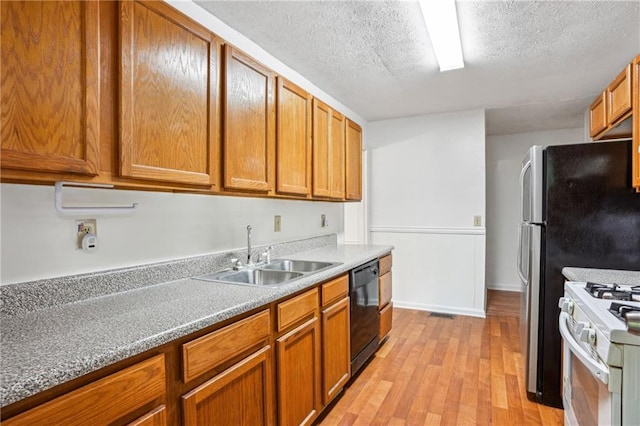 kitchen with white range with gas cooktop, brown cabinetry, a textured ceiling, black dishwasher, and a sink