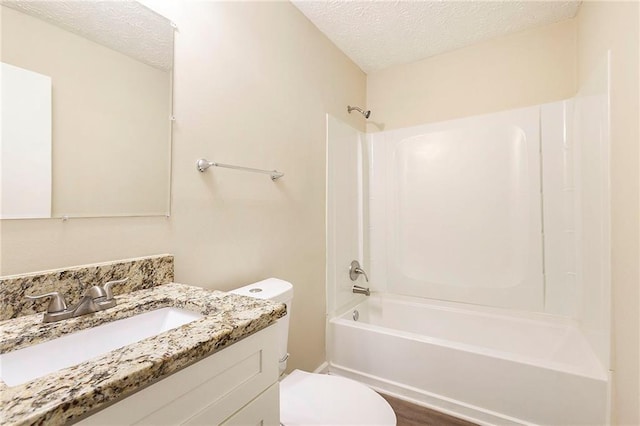 full bathroom with a textured ceiling, hardwood / wood-style floors, toilet, shower / bath combination, and vanity