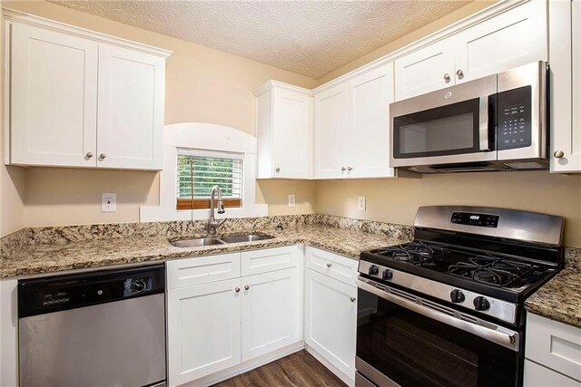 kitchen with sink, white cabinetry, stainless steel appliances, and a textured ceiling