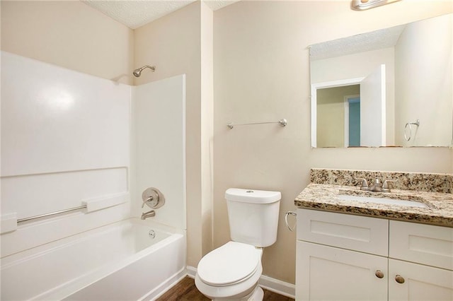 full bathroom featuring washtub / shower combination, a textured ceiling, hardwood / wood-style floors, toilet, and vanity