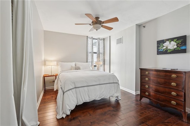 bedroom featuring dark hardwood / wood-style flooring, ceiling fan, and ensuite bath