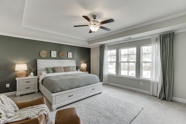 bedroom featuring crown molding, ceiling fan, a tray ceiling, and light carpet