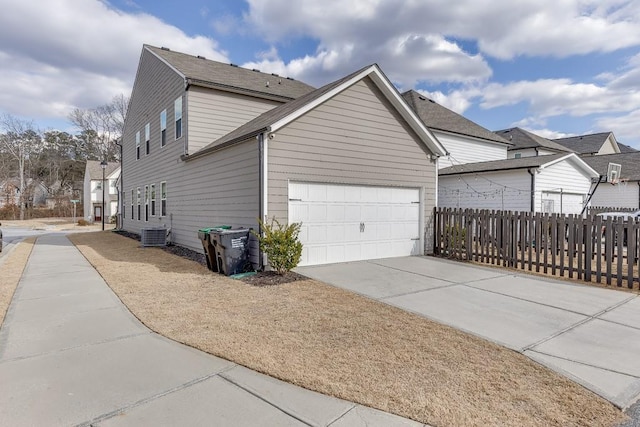 view of property exterior with a garage and central AC