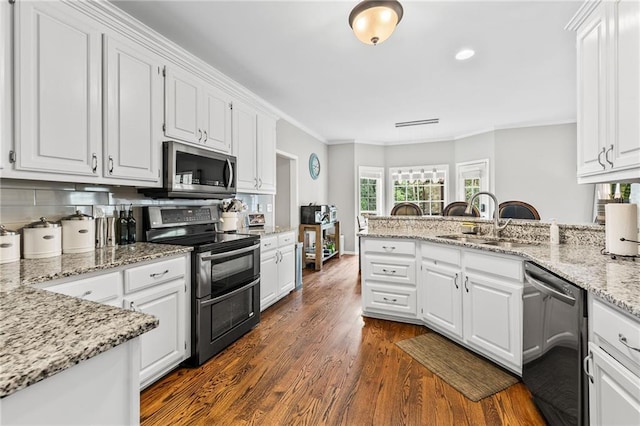 435 Ruby Forest Pkwy, Suwanee, GA 30024 - kitchen featuring stainless steel appliances, a sink, dark wood-type flooring, white cabinets, and ornamental molding