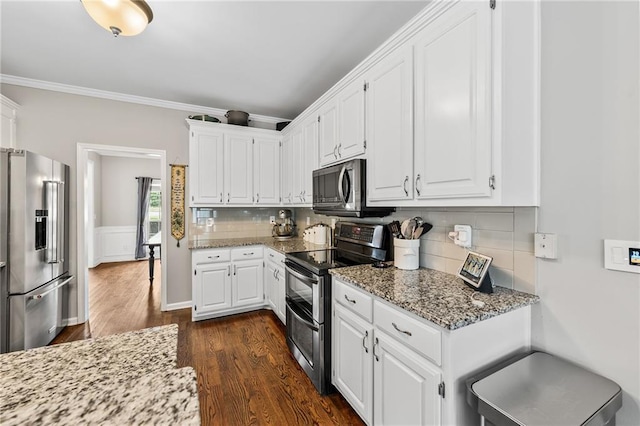 435 Ruby Forest Pkwy, Suwanee, GA 30024 - kitchen with appliances with stainless steel finishes, dark wood-type flooring, white cabinets, light stone counters, and ornamental molding