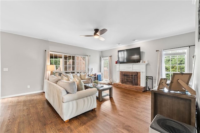 435 Ruby Forest Pkwy, Suwanee, GA 30024 - living area with ceiling fan, a brick fireplace, wood finished floors, crown molding, and baseboards