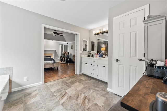 435 Ruby Forest Pkwy, Suwanee, GA 30024 - ensuite bathroom featuring ceiling fan, vanity, a bath, baseboards, and a fireplace