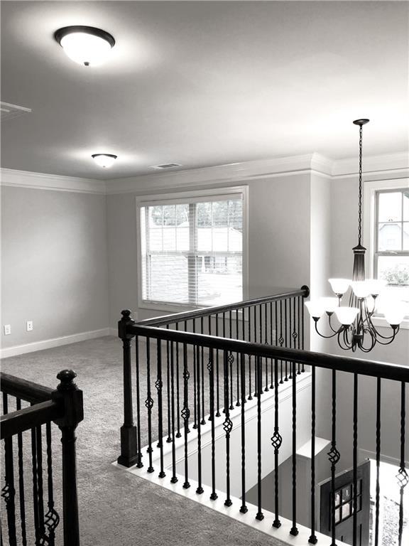 149 Elkins Blvd, Locust Grove, GA 30248 - hallway featuring a notable chandelier, crown molding, and carpet flooring