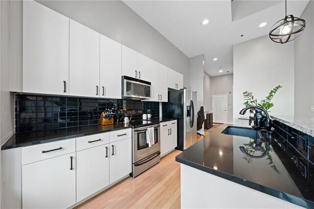 44 Peachtree Pl NW Unit 528, Atlanta, GA 30309 - kitchen featuring a sink, light wood-style floors, stainless steel appliances, backsplash, and recessed lighting