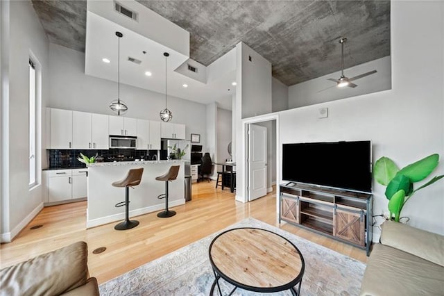 44 Peachtree Pl NW Unit 528, Atlanta, GA 30309 - living area with a towering ceiling, visible vents, and light wood-style flooring