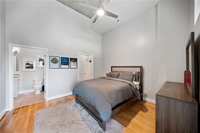 44 Peachtree Pl NW Unit 528, Atlanta, GA 30309 - bedroom with ensuite bath, baseboards, light wood-style flooring, and a high ceiling