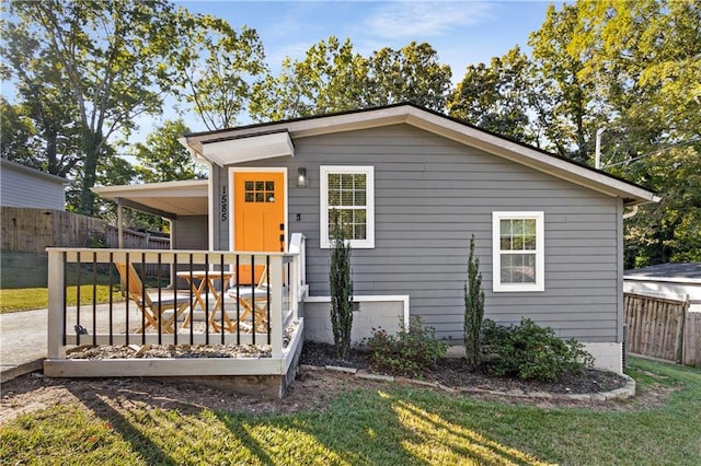 view of front of house with a wooden deck and a front yard