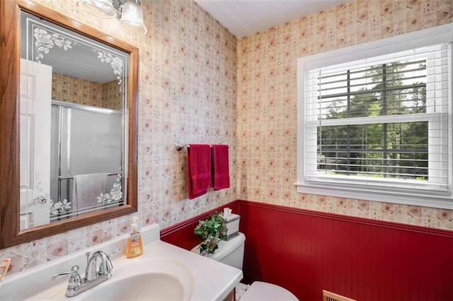 3359 Villa Ln, Douglasville, GA 30135 - bathroom with a stall shower, vanity, wallpapered walls, and wainscoting