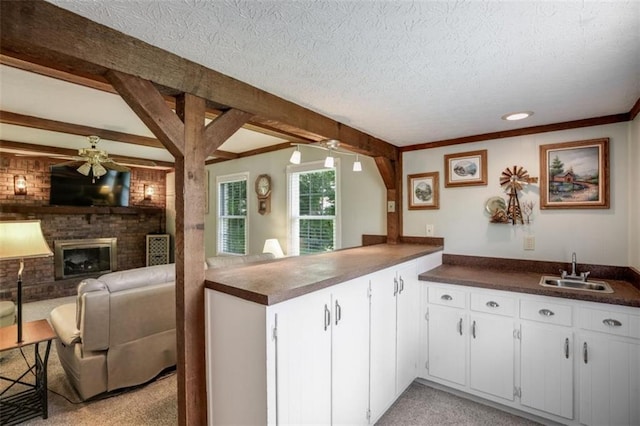 3359 Villa Ln, Douglasville, GA 30135 - kitchen with open floor plan, dark countertops, ceiling fan, a brick fireplace, and a textured ceiling