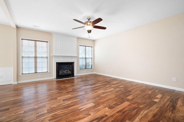 unfurnished living room featuring a ceiling fan, a fireplace, dark wood finished floors, and visible vents