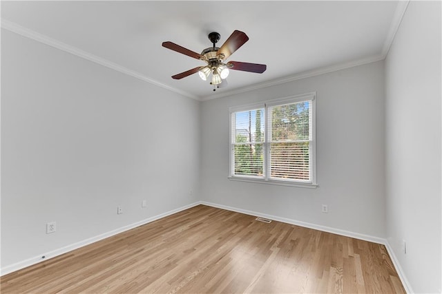 spare room featuring visible vents, baseboards, light wood-style flooring, and crown molding