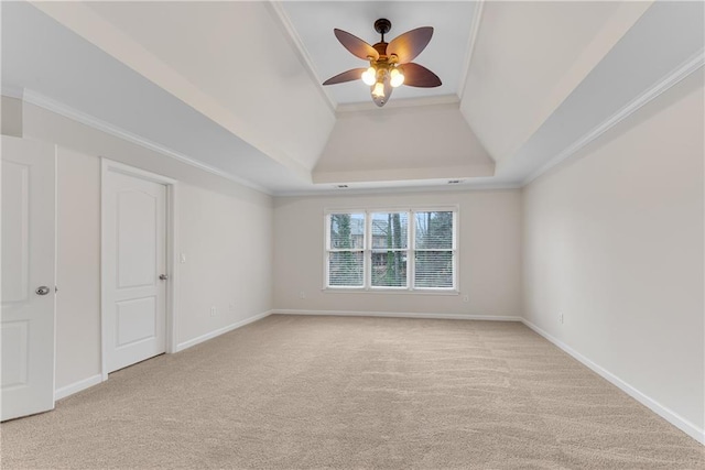 empty room featuring light carpet, baseboards, a tray ceiling, and a ceiling fan