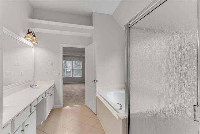 full bath featuring a sink, a garden tub, double vanity, and tile patterned flooring