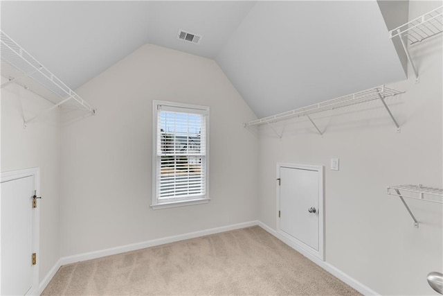 spacious closet featuring vaulted ceiling, carpet flooring, and visible vents