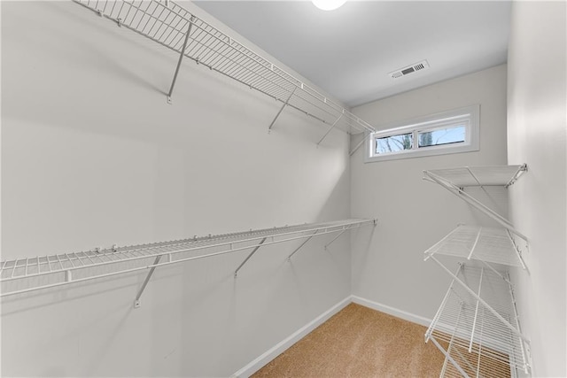 walk in closet featuring visible vents and light colored carpet