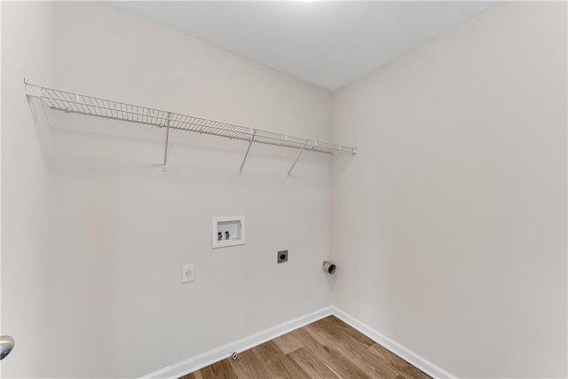 clothes washing area with wood finished floors, baseboards, hookup for an electric dryer, hookup for a washing machine, and laundry area