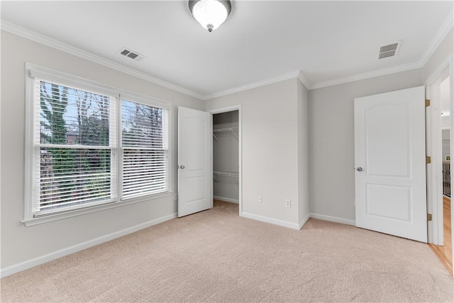 unfurnished bedroom with ornamental molding, baseboards, visible vents, and light carpet