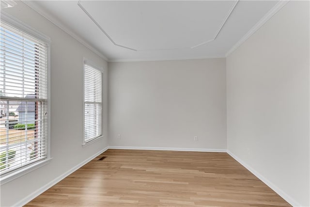 unfurnished room featuring crown molding, plenty of natural light, light wood-style floors, and baseboards