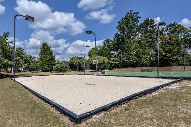 view of property's community with community basketball court and a yard