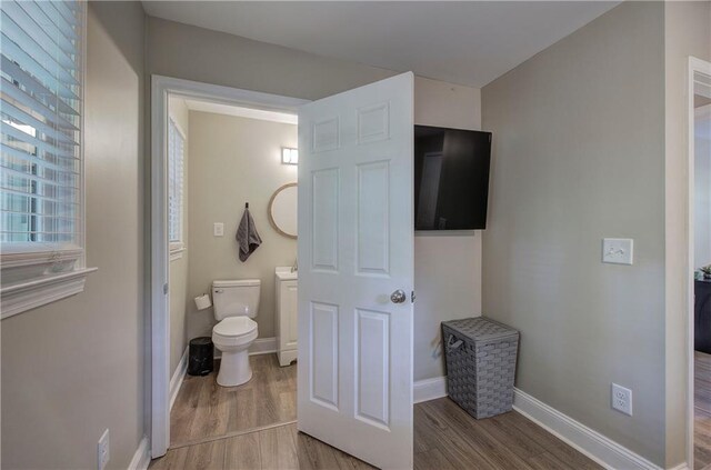 bathroom featuring toilet, baseboards, and wood finished floors