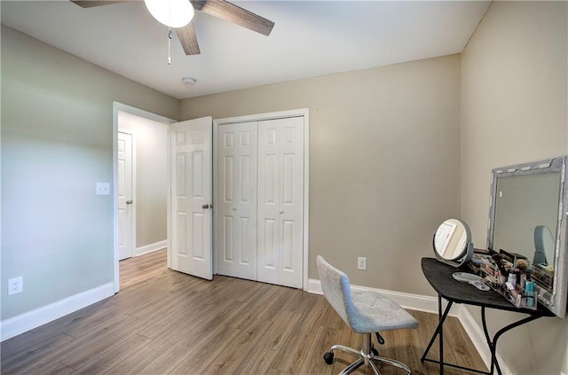 home office with baseboards, light wood-style flooring, and ceiling fan