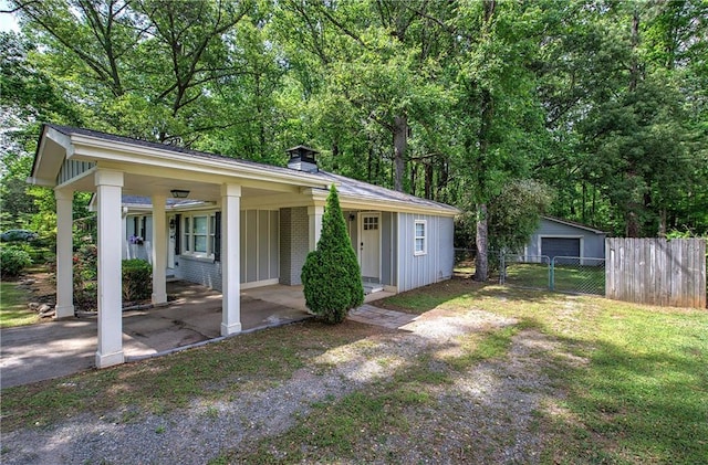 view of front of home with fence, covered porch, a chimney, driveway, and a detached garage