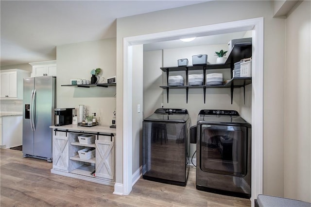 laundry area with light wood-style floors, laundry area, and independent washer and dryer