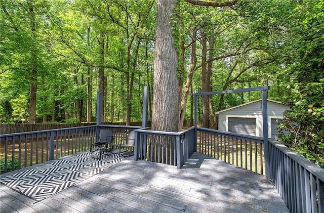 wooden terrace featuring a garage and an outbuilding
